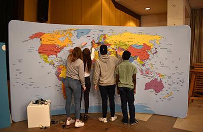 Schüler stehen vor Weltkarte