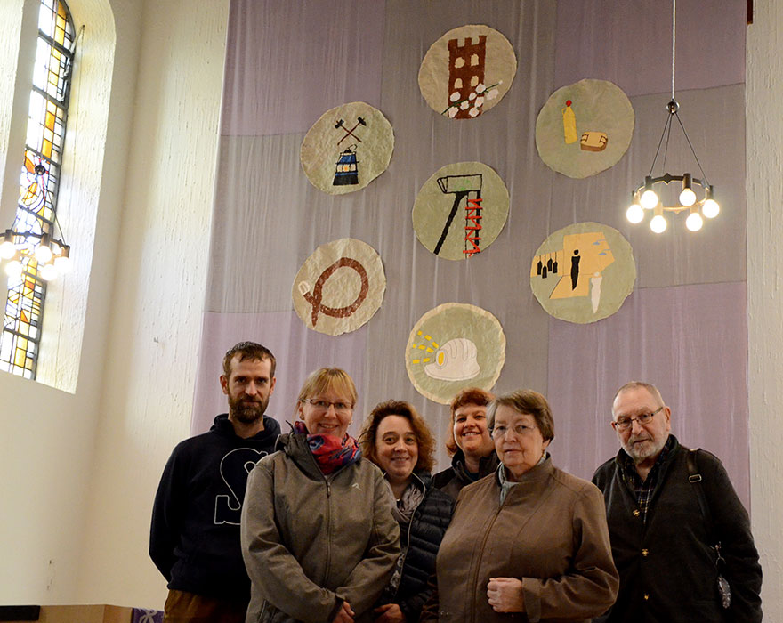 Vor dem Hungertuch mit den Bergbaumotiven stehen (von links) Michael Kulmann, Bettina Högn, Melanie Nowka, Kristina Wenner, Cäcilia Braukmann und Pfarrer em. Franz Durkowiak.