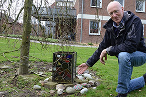 Ferdi Schilles zeigt auf den Erinnerungsbaum und die gestalteten Steine für die Verstorbenen.
