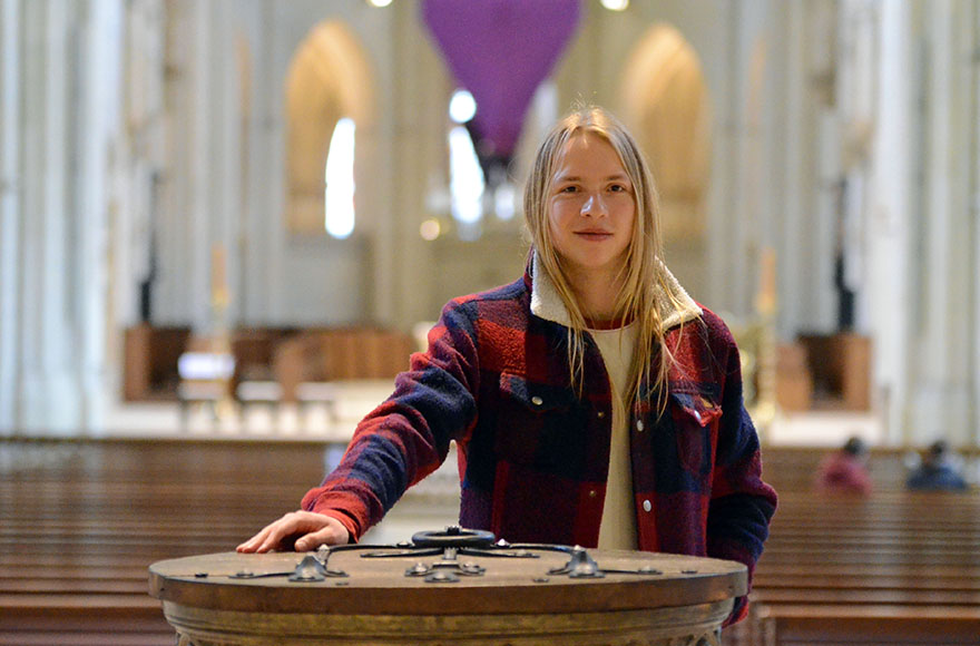 Coraghessan Steinbach steht am Taufbecken im St.-Paulus-Dom. 