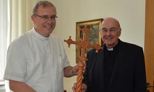 Die Bischöfe Johannes Bahlmann (links) und Felix Genn halten zwischen sich das Kreuz aus hellbraunem Zedernholz. Die Bischöfe Johannes Bahlmann (links) und Felix Genn halten zwischen sich das Kreuz aus hellbraunem Zedernholz.