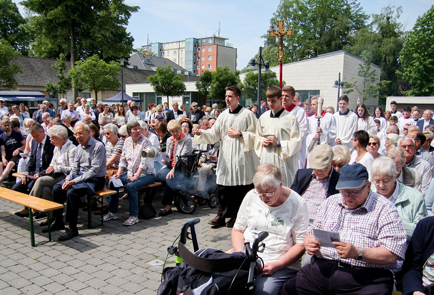 Einzug der Messdiener bei einem Gottesdienst unter freiem Himmel.