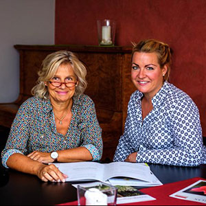Claudia Bonenkamp (links) und Alexandra Hieck sitzen gemeinsam am Tisch.
