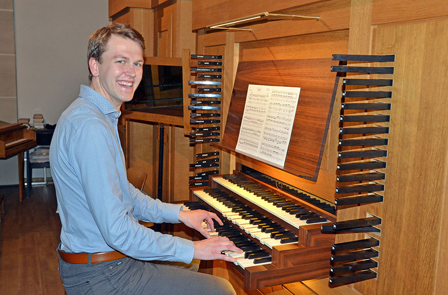 Simon Halfmann sitzt an der Orgel. 