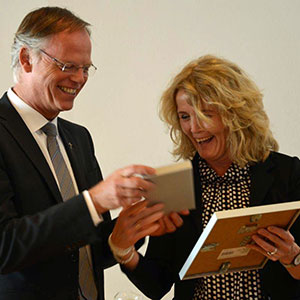 Generalvikar Dr. Klaus Winterkamp überreicht Birgit Schleithoff zum 25-jährigen Dienstjubiläum eine Urkunde und ein Präsent.