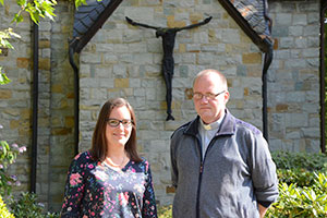 Caroline Johnen und Pfarrer Ulrich Witte stehen vor einem Kreis der Kirche in Kirchhhellen.