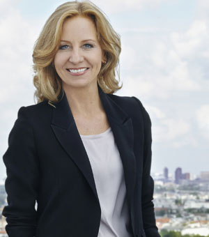 Patricia Schlesinger steht lächelnd auf einem Dach, im Hintergrund ist die Skyline Berlins zu sehen.