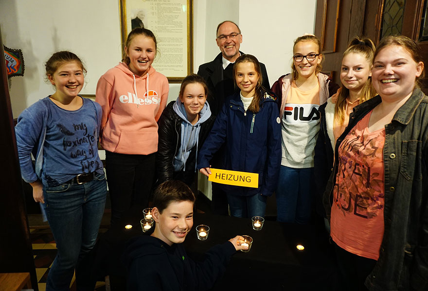 Der Weihbischof steht zwischen jugendlichen Teilnehmern.