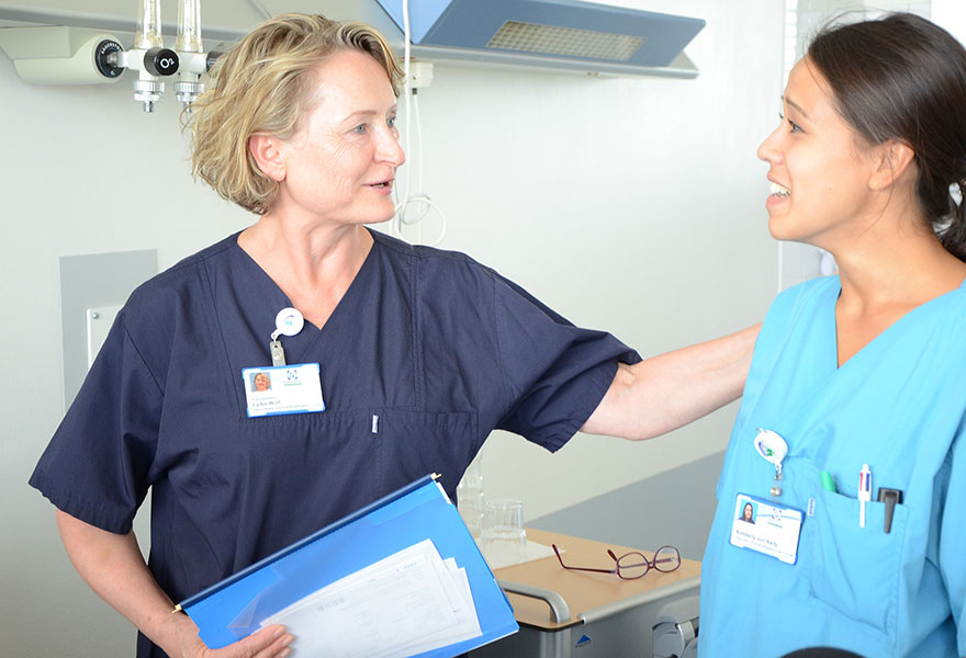 Lydia Wolf leitet eine Auszubildende im Krankenhaus an. Lydia Wolf leitet eine Auszubildende im Krankenhaus an.