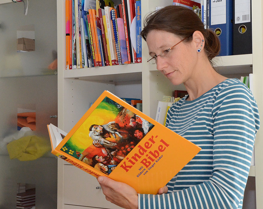 Christiane Zirpel schaut in eine Kinderbibel. 