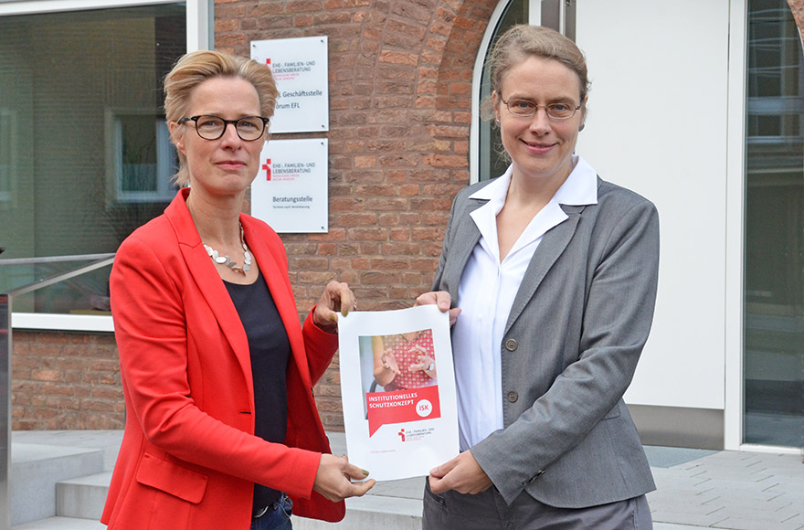 Andrea Stachon-Groth und Petra Häder halten die Titelseite des Institutionellen Schutzkonzeptes in den Händen. 