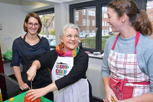 Edith Gätjen zeigt den Teilnehmerinnen Lena Jansen und Katrin Pasch den richtigen Umgang mit einem Kürbis.