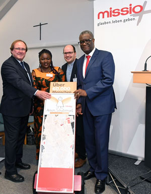 (v.l.) Dr. Stefan Oswald vom Bundesministerium für wirtschaftliche Zusammenarbeit und Entwicklung; Thérèse Mema Mapenzi, Leiterin Centre OLAME Bukavu, missio-Projektpartnerin; Pfarrer Dirk Bingener, Präsident missio Aachen; Dr. Denis Mukwege, Leiter Panzi-Hospital Bukavu und Träger des Friedensnobelpreises 2018 präsentieren eine Unterschriftenbox der Aktion Goldengel