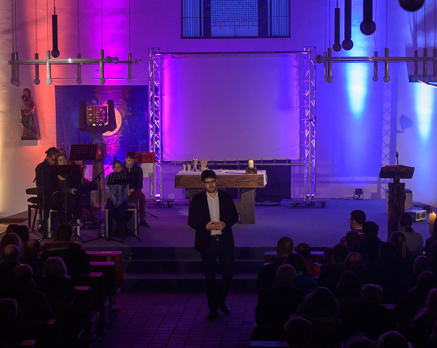 Szene aus einer bunt ausgeleuchteten Kirche bei einem Areopray-Gottesdienst.