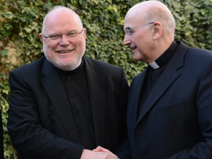 Kardinal Reinhard Marx, Vorsitzender der Deutschen Bischofskonferenz, und Münsters Bischof Felix Genn reichen sich die Hände.