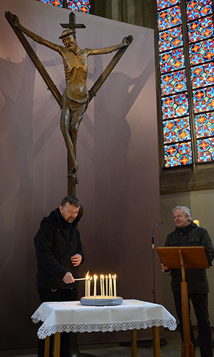 Während Pfarrdechant Johannes Arntz (rechts) die Fürbitten vorträgt, entzündet Christian Fechtenkötter, Pastoralassistent und Diakon, für jede Bitte vor dem Coesfelder Kreuz eine Kerze.