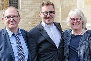 Alexander Senk steht nach der Priesterweihe zwischen seinen Eltern.