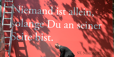 Pfarrer Dr. Jochen Reidegeld vor einem Plakat Pfarrer Dr. Jochen Reidegeld vor einem Plakat