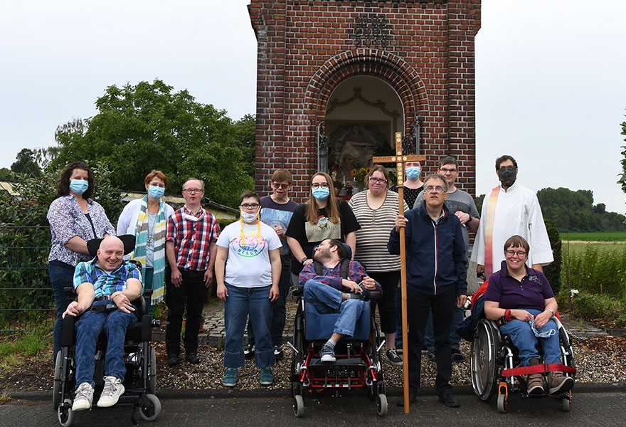 Die Gruppe hat sich vor einer Kapelle zum Gruppenbild aufgestellt.