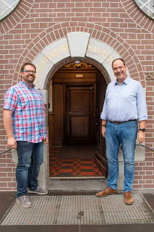 Zwei Männer stehen vor der geöffneten Pforte am Priesterhaus in Kevelaer.