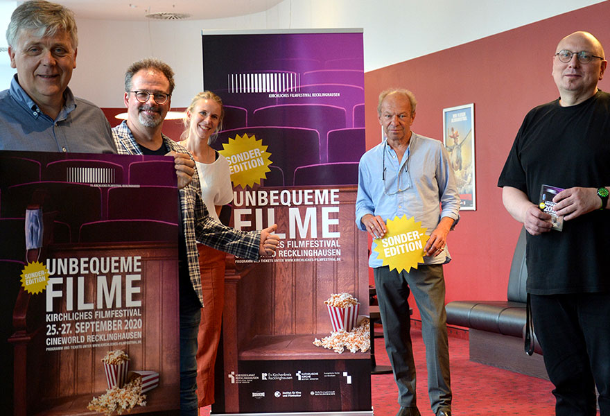 Pastoralreferent Joachim van Eickels, der künstlerische Leiter Michael M. Kleinschmidt, Julia Borries vom evangelischen Erwachsenenbildungswerk, Pfarrer Harald Wagner sowie Kai-Uwe Theveßen, Theaterleiter des Cineworld, stehen vor dem Plakat des Festivals.