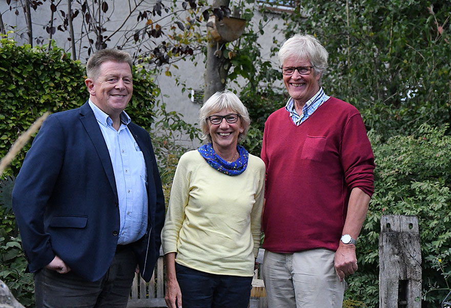 Pfarrdechant Norbert Caßens, Margret Hattrup und Ulrich Suttrup (von links) stehen nebeneinander und lächeln in die Kamera.