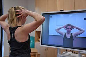 Sonja Bröckerhoff macht eine Übung vor dem Fernseher vor. Sonja Bröckerhoff macht eine Übung vor dem Fernseher vor.