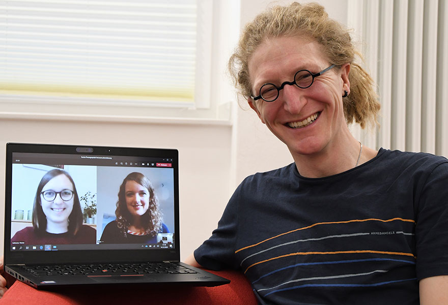 Theresa Sothmann von der KSHG, Autorin Hanna Buiting sind auf dem Laptop zu sehen, den Pastoralreferent Daniel Gewand in der Hand hat.