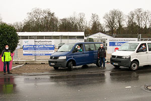 Vor dem Impfzentrum stehen zwei Bullis mit den Organisatoren und Ehrenamtlichen.