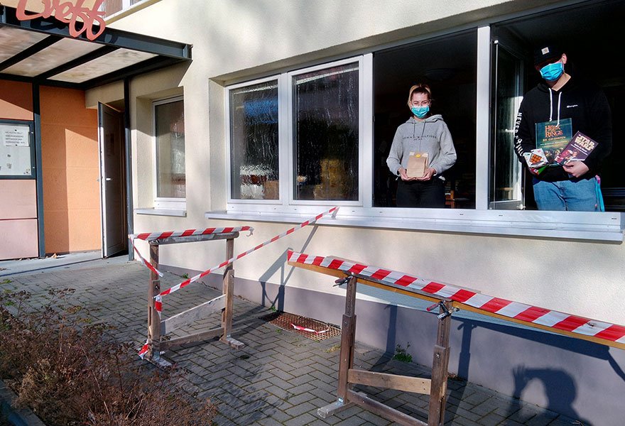 Am Fenster des und Luca Sörries und haben eine Tüte sowie Bücher und Spiele in der Hand.