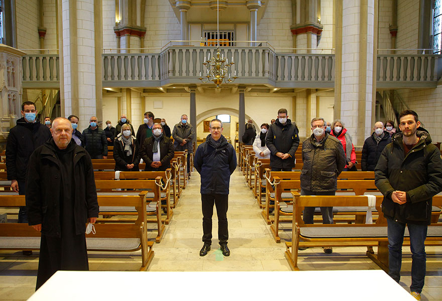 Die Beteiligten des Gesprächs haben sich in der Kirche verteilt. In der Mitte steht Marc Heilenkötter.