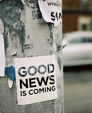 Ein an einem Laternenmast befestigter Aufkleber mit der Aufschrift "GOOD NEWS IS COMING".