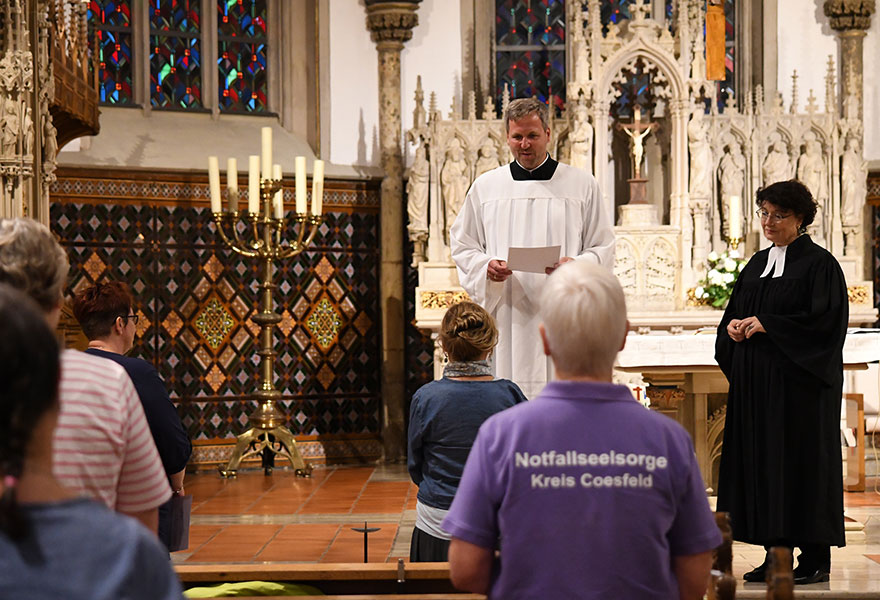 Andreas Naumann Hinz und Alexandra Hippchen sind in einer Kirche und beauftragen die neuen Notfallseelsorger.