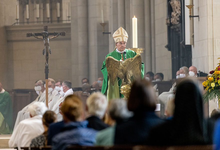 Der Bischof steht am Ambo im Dom und spricht.