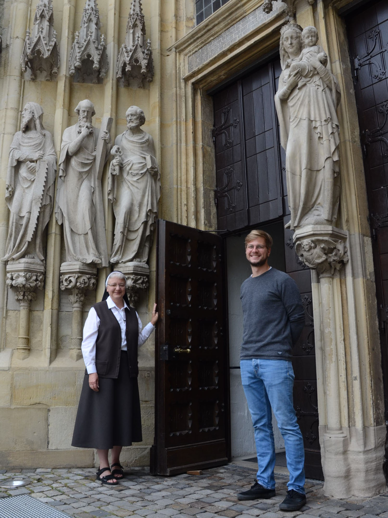 Schwester Katharina Kluitmann und Stefan Scholtyssek vorm Eingangsprotal der Überwasserkirche.