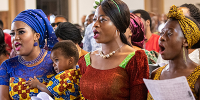 Frauen in traditionellen Gewändern beim Singen im Gottesdienst