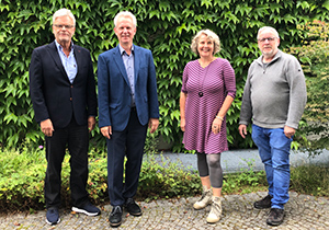 Werner Schniedermann, Antonius Kerkhoff, Maria Terbeck und Herrmann Hölscheidt stehen in der Gartenanlage der Akademie Franz Hitze Haus.