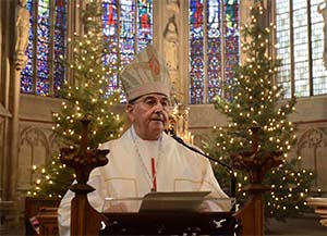 Bischof Felix Genn am Ambo von St. Lamberti, im Hintergrund sind Weihnachtsbäume zu erkennen.