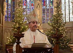 Bischof Felix Genn (Archivfoto) Bischof Genn am Ambo, im Hintergrund leuchten Weihnachtsbäume