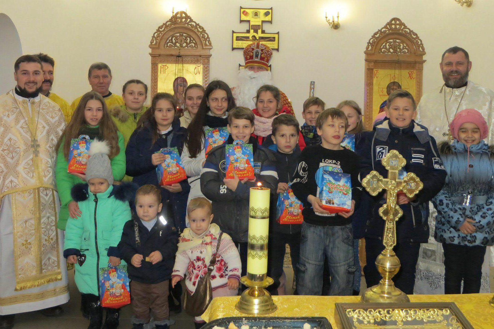 Gruppenbild von Geistlichen und Kindern, die Kinder halten Geschenke in ihren Händen. 