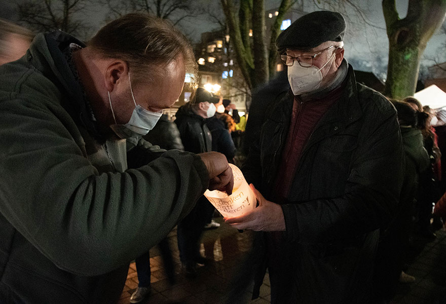 Wilhelm Heek zündet die Kerze in einem Windlicht an.