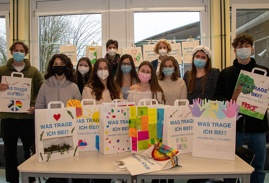 Schülerinnen und Schüler stehen hinter den bunt gestalteten Papiertaschen.