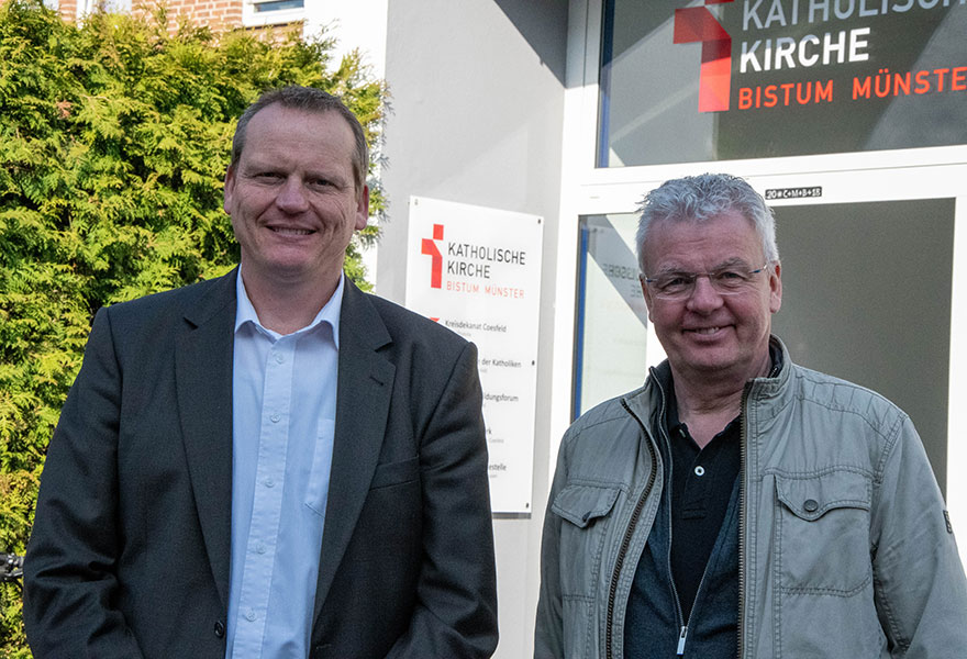 Kreisdechant Johannes Arntz (rechts) und Benedikt Helmich, Geschäftsführer des Kreisdekanatsbüros, stehen nebeneinander und lächeln in die Kamera.