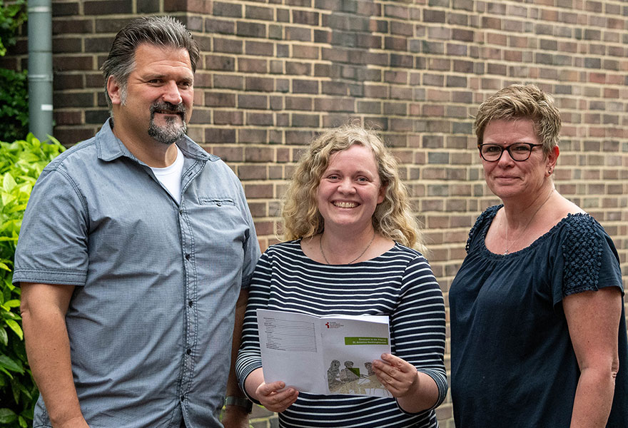 Ralf Nopper vom Leitungsteam, Pastoralreferentin Katharina Müller und Begleiterin Bianca Wimmer stehen nebeneinander und lächeln in die Kamera.