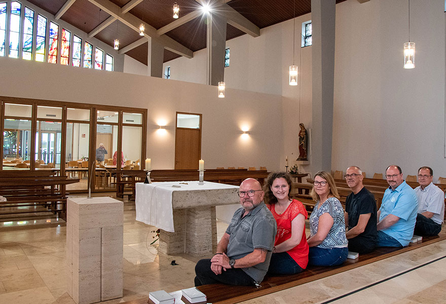 Vorne sitzen die am Umbau Beteiligten nebeneinander. Sie geben den Blick in die Kirche frei.