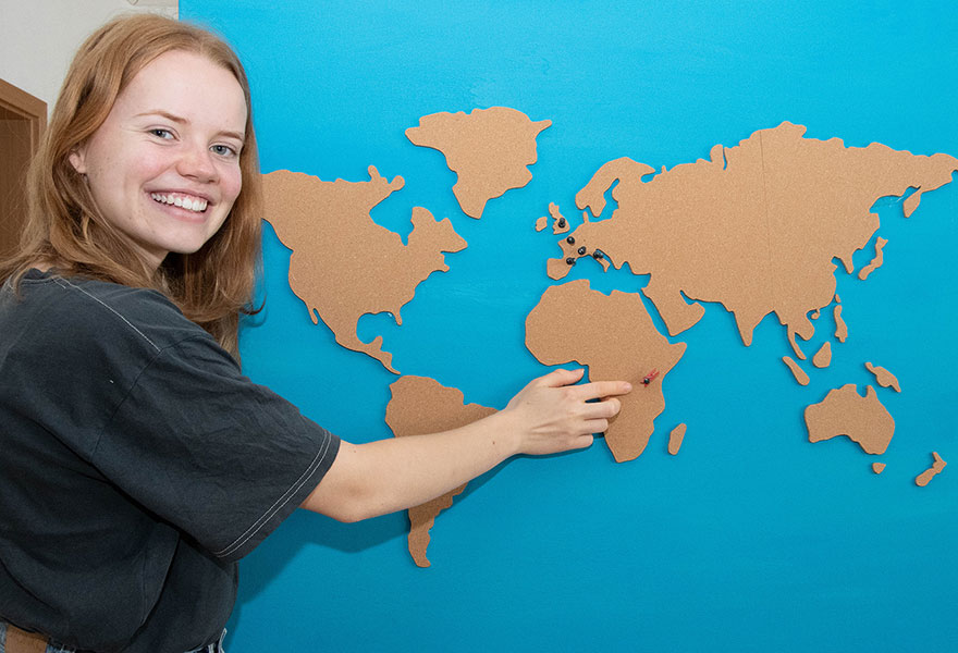 Samira Schulte zeigt auf einer selbst gestalteten Weltkarte auf Uganda.