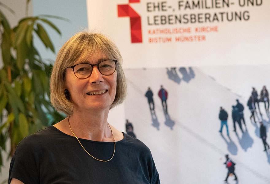 Dr. Elisabeth Chmielus, Leiterin der Ehe-, Familien- und Lebensberatung in Lüdinghausen, steht vor einem Aufsteller der Ehe-, Familien- und Lebensberatung.