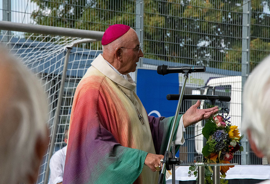 Der Bischof steht am Mikrofon und spricht.