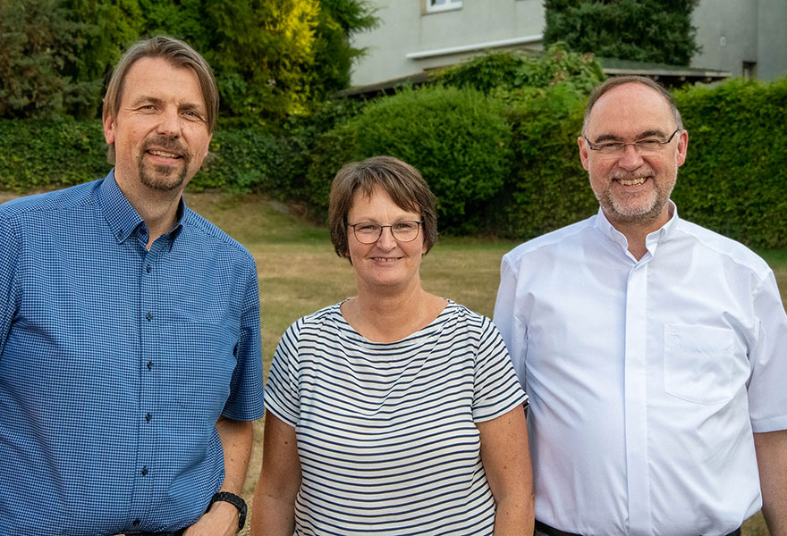 Matthias Mamot, Irmgard Heimbach und Weihbischof Rolf Lohmann stehen nebeneinander und lächeln in die Kamera.