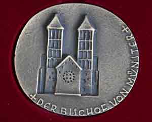 Eine runde Bronzeplakette zeigt den Dom von Münster und ist Der Bischof von Münster umschrieben. Eine runde Bronzeplakette zeigt den Dom von Münster und ist Der Bischof von Münster umschrieben.